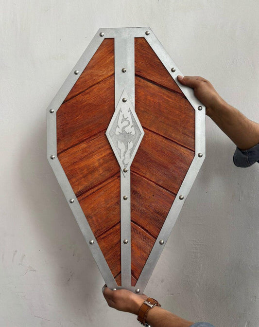 Wooden wall art piece with metal frame being held against a white wall