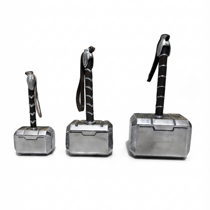 Three metallic hammer-shaped accessories arranged by size on a plain white background, each with a black handle and silver head.